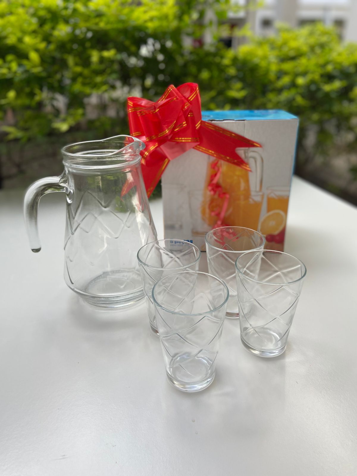 Jarra de vidrio y 4 vasos de vidrio labraditos en caja